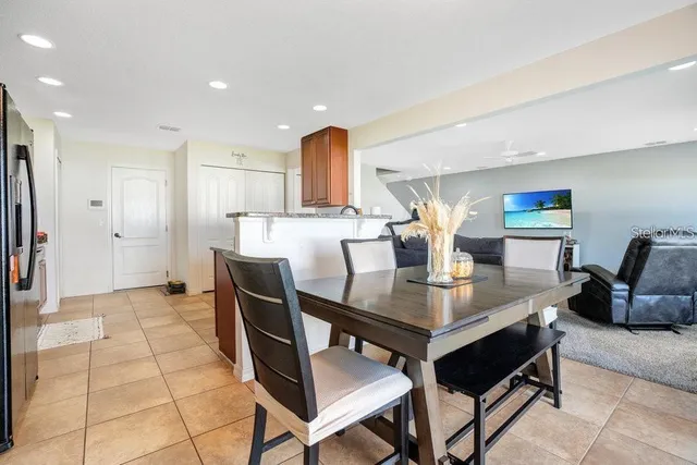 a kitchen with stainless steel appliances kitchen island granite countertop a table chairs in it and wooden floors