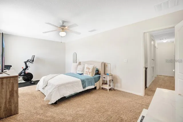 a spacious bedroom with a bed and a chandelier