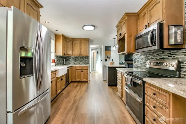 a bathroom with a granite countertop sink toilet and mirror
