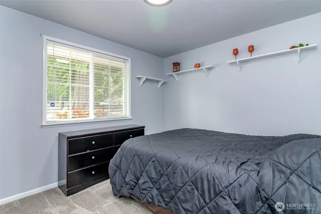 a large bed sitting in a bedroom next to a window