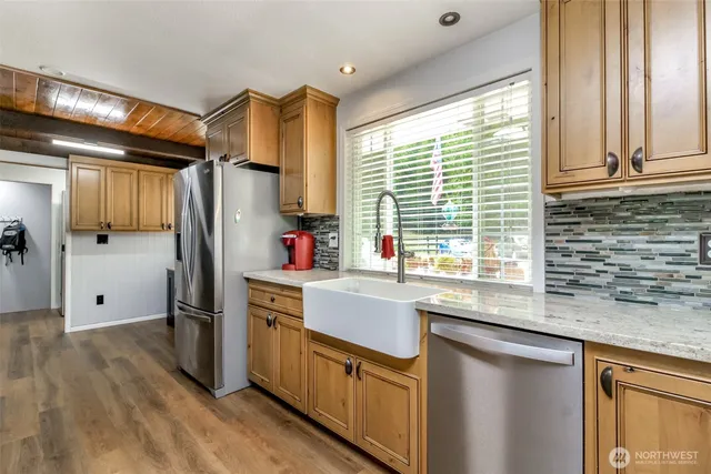 a kitchen with stainless steel appliances granite countertop a refrigerator and a sink