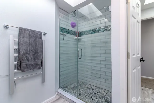 a living room with furniture and a flat screen tv with kitchen view