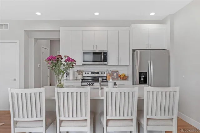 a kitchen that has a microwave a refrigerator and a sink