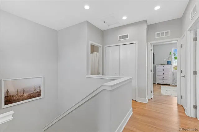 a hallway with wooden floor and cabinet