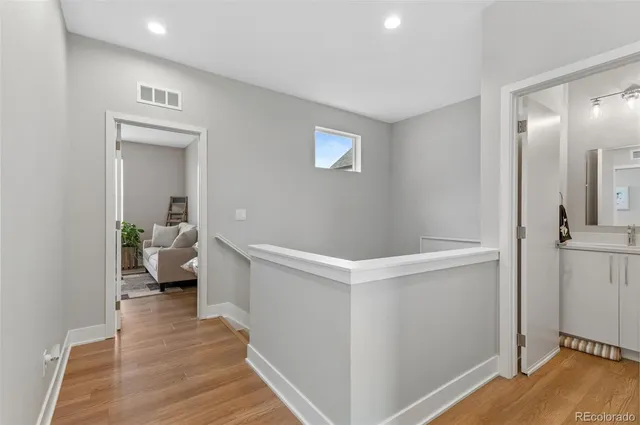 a hallway with white cabinets and wooden floor