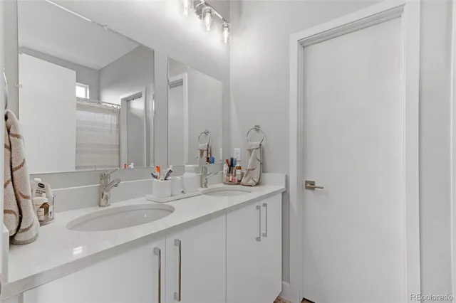a bathroom with double sink and a mirror