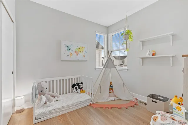 a view of a bedroom with baby crib and lounge chair