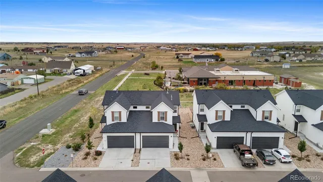 an aerial view of a city with lots of residential buildings and ocean view in back