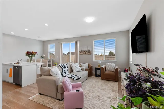 a living room with furniture a flat screen tv and a window