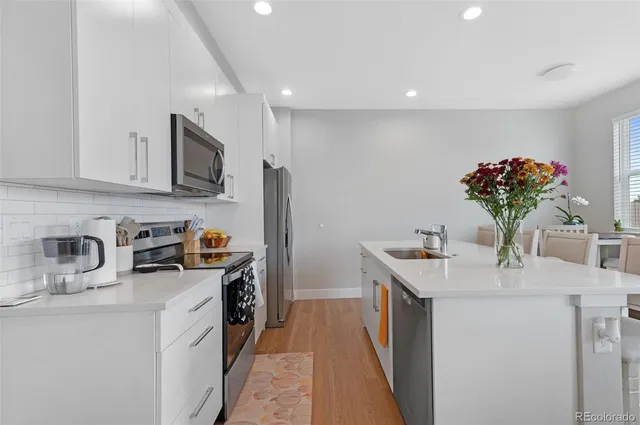 a kitchen with stainless steel appliances granite countertop a sink stove and refrigerator