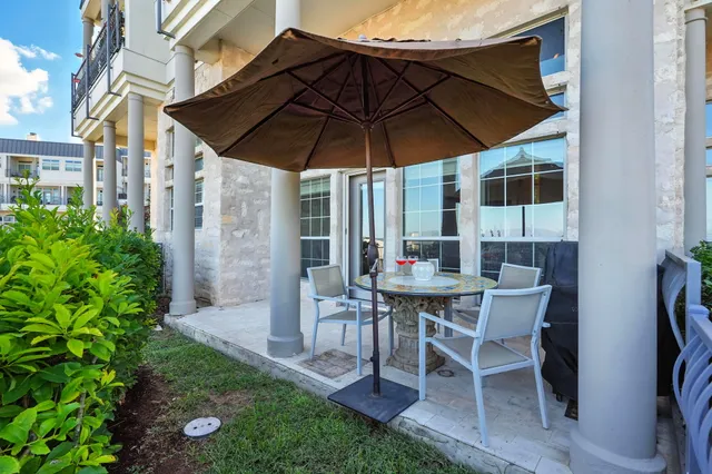 a patio with a table and chairs under an umbrella