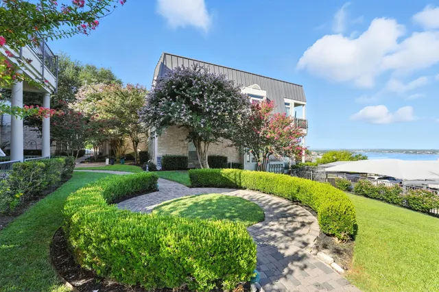a view of a house with a yard and potted plants