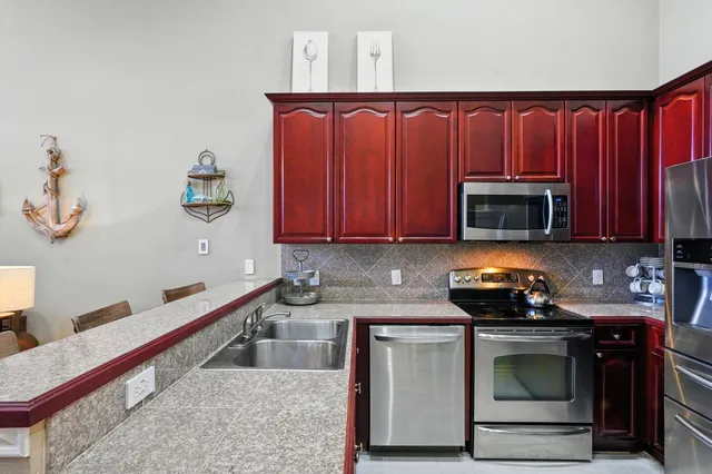 a kitchen with stainless steel appliances granite countertop a stove a microwave a sink and cabinets