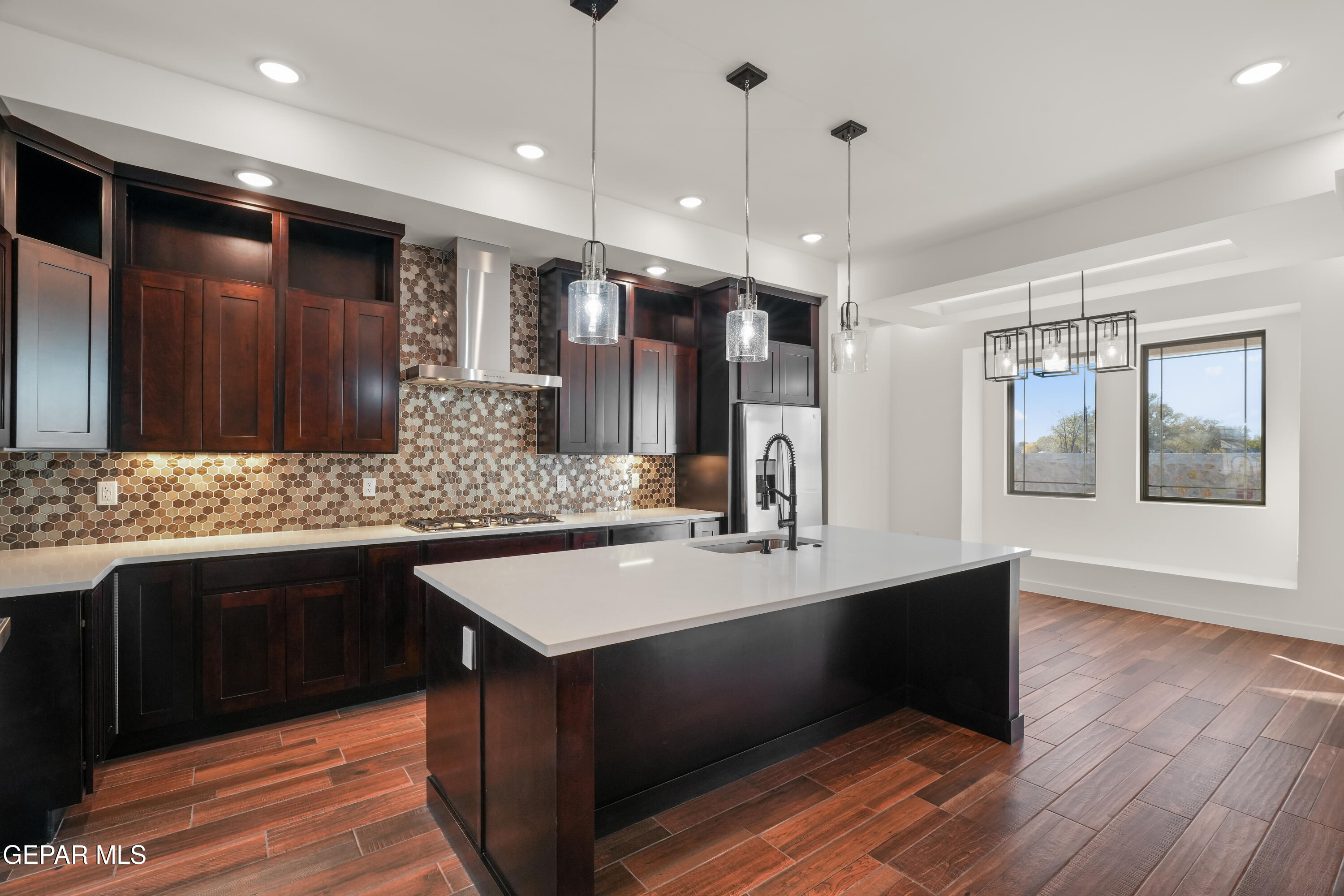 5953 Ruidoso Downs Street El Paso, TX 79932 - Photo 11 of 56 a kitchen with kitchen island granite countertop a sink and a stove