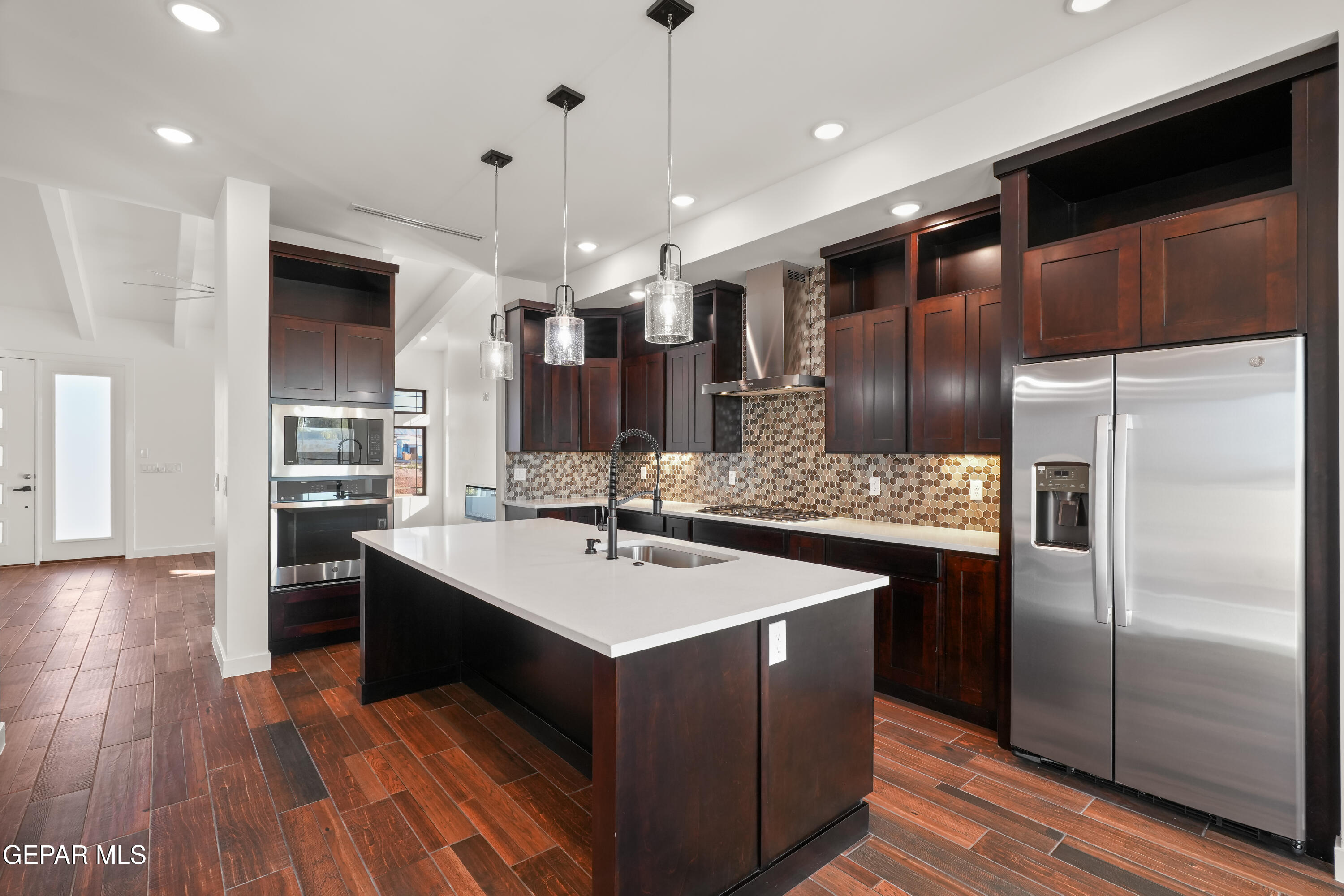 5953 Ruidoso Downs Street El Paso, TX 79932 - Photo 15 of 56 a kitchen with kitchen island a sink stove and refrigerator