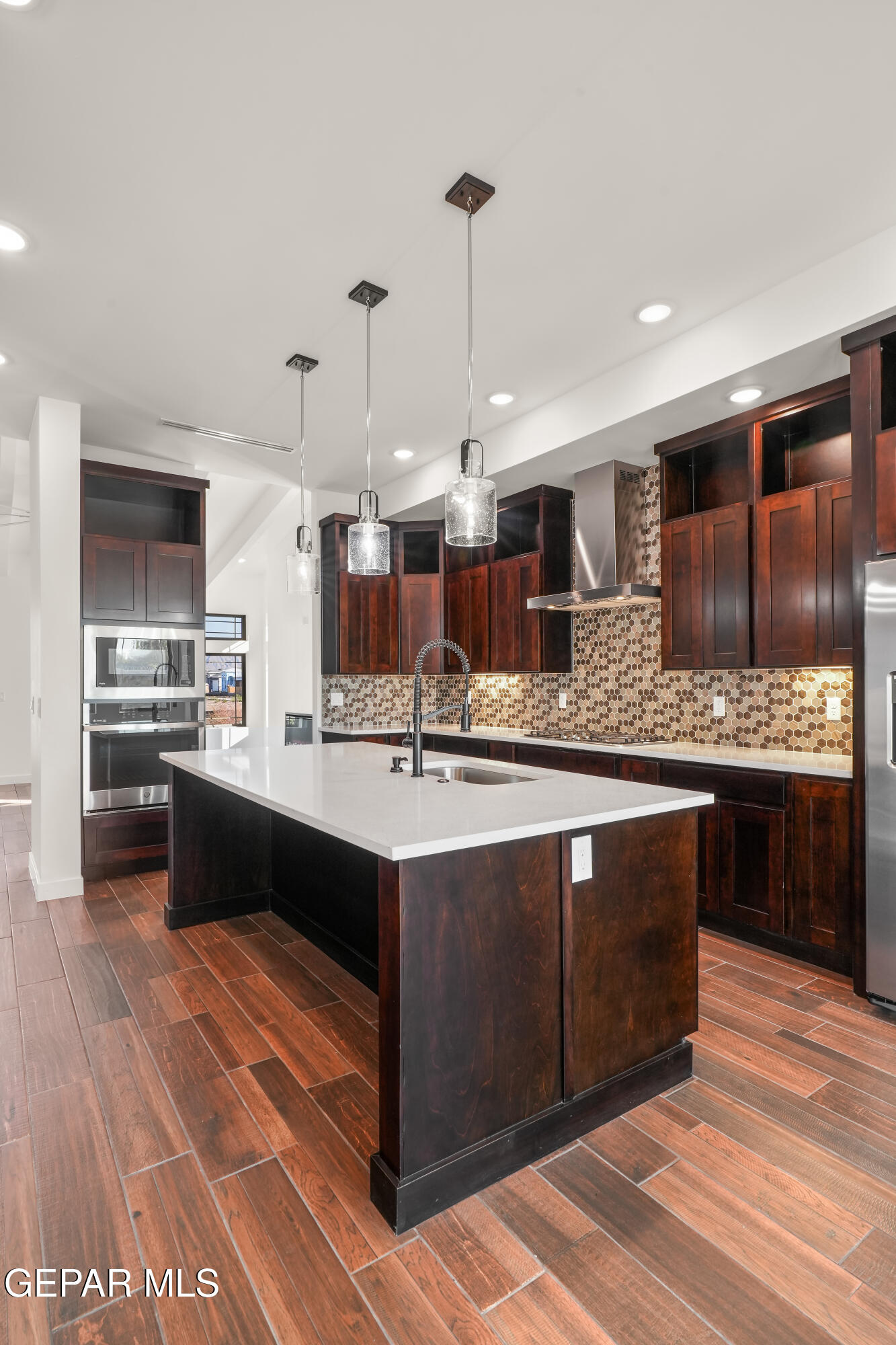 5953 Ruidoso Downs Street El Paso, TX 79932 - Photo 17 of 56 a large kitchen with stainless steel appliances kitchen island granite countertop a sink and cabinets