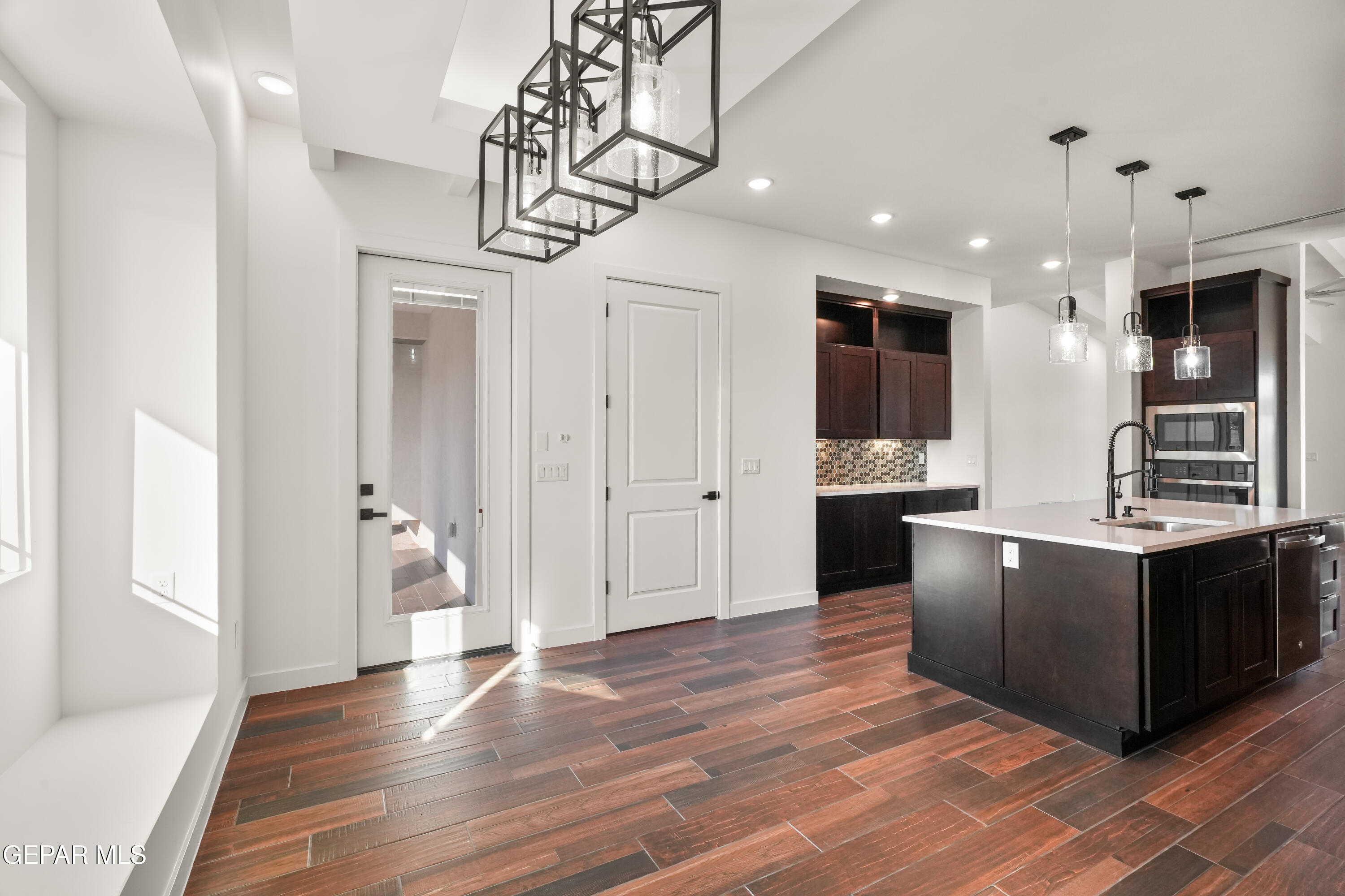 5953 Ruidoso Downs Street El Paso, TX 79932 - Photo 19 of 56 a large kitchen with stainless steel appliances kitchen island granite countertop a large counter top and wooden floors