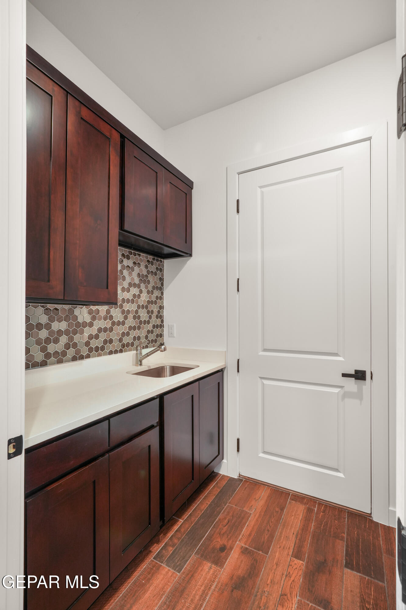 5953 Ruidoso Downs Street El Paso, TX 79932 - Photo 26 of 56 a kitchen with a sink a refrigerator and wooden cabinets