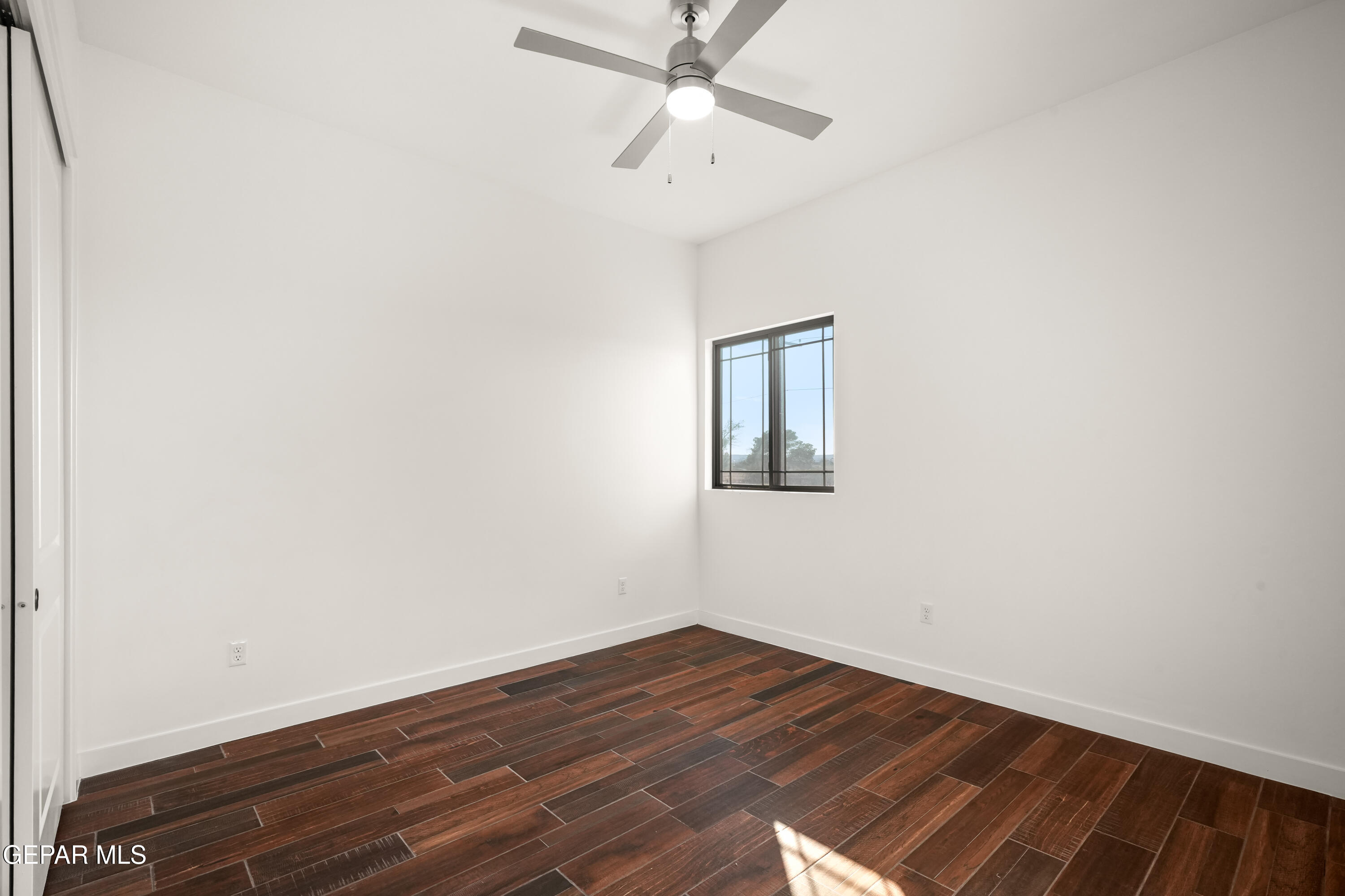 5953 Ruidoso Downs Street El Paso, TX 79932 - Photo 40 of 56 an empty room with wooden floor and fan