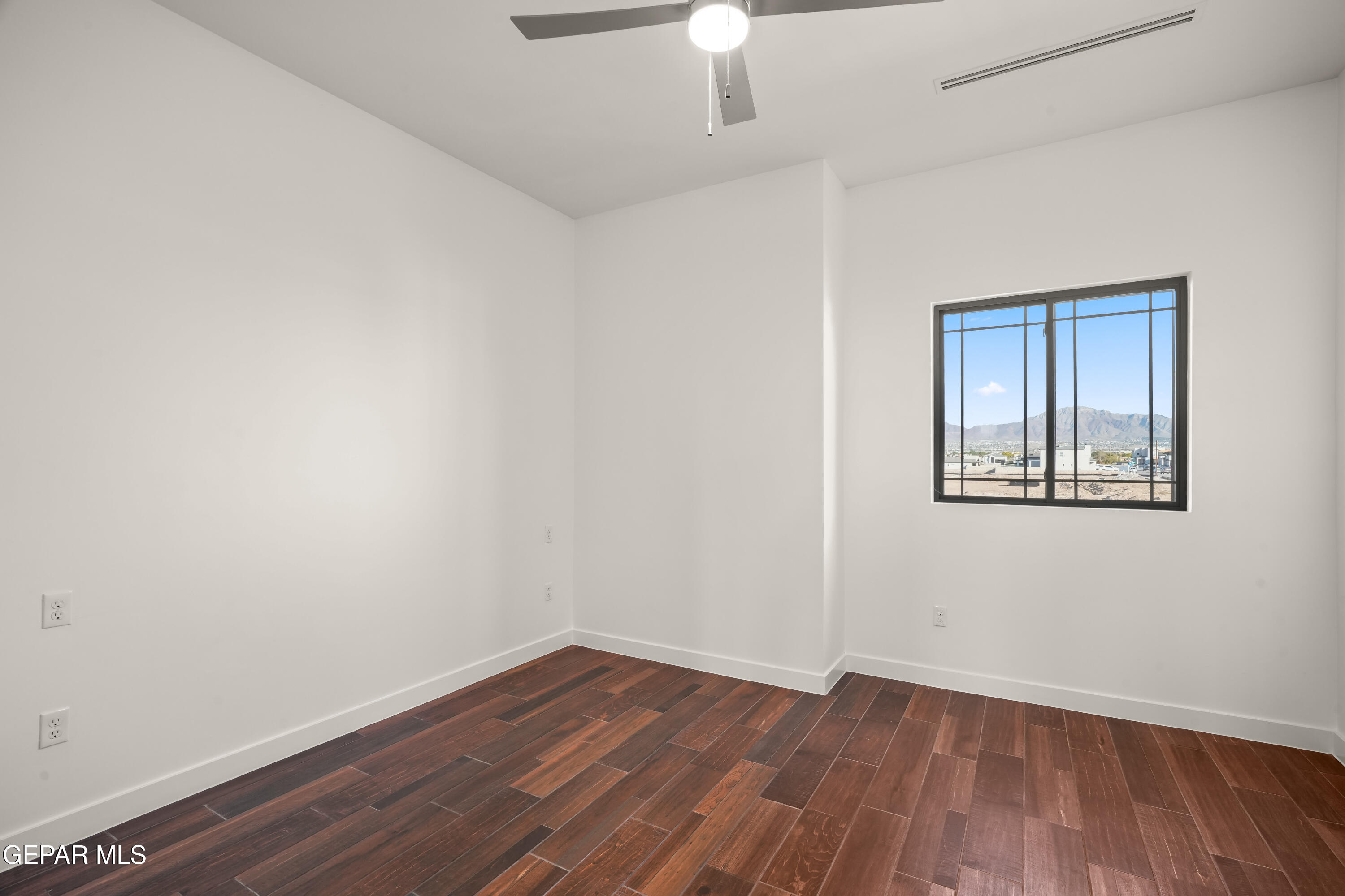5953 Ruidoso Downs Street El Paso, TX 79932 - Photo 44 of 56 an empty room with wooden floor chandelier fan and windows
