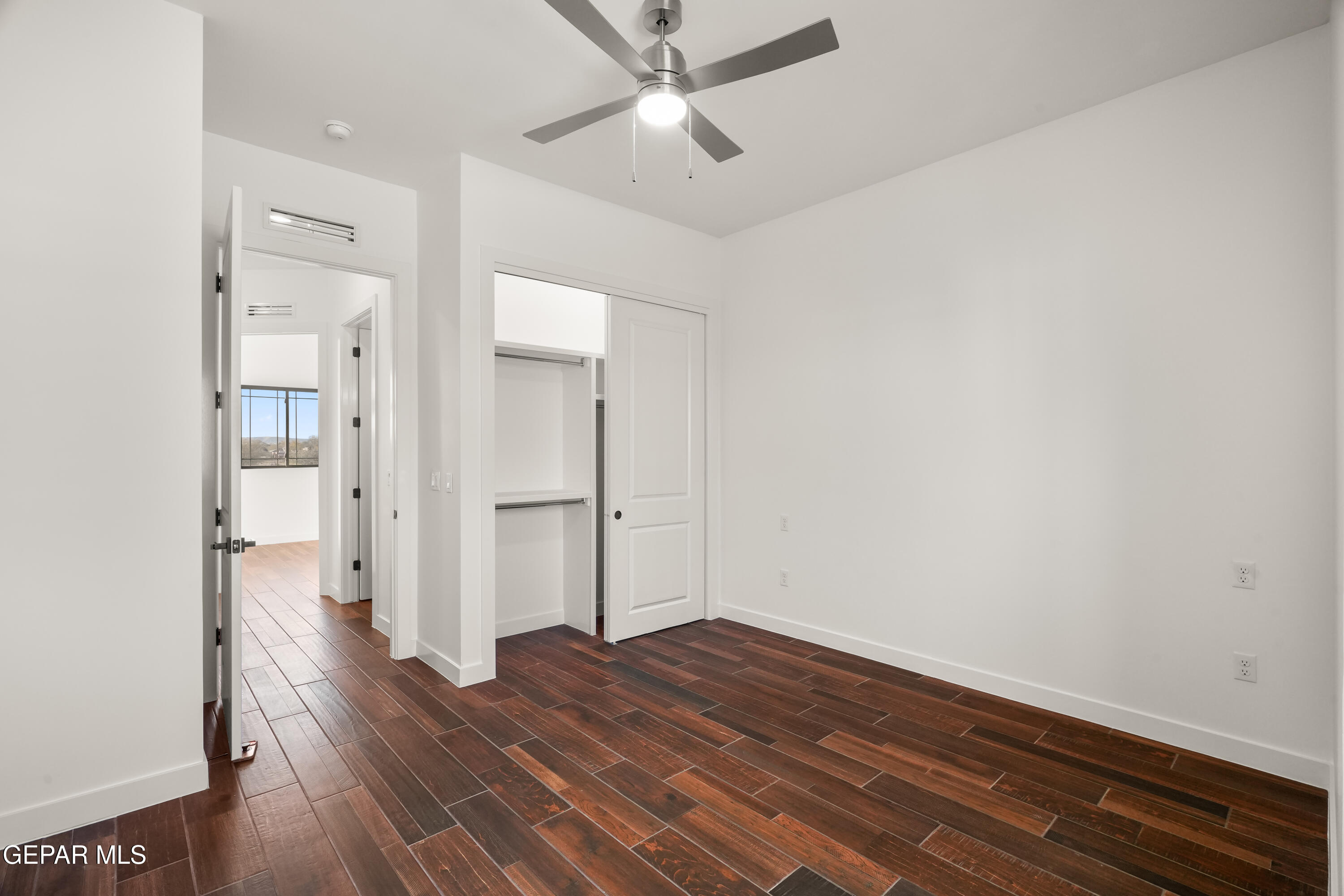 5953 Ruidoso Downs Street El Paso, TX 79932 - Photo 45 of 56 a view of a room with wooden floor and a ceiling fan
