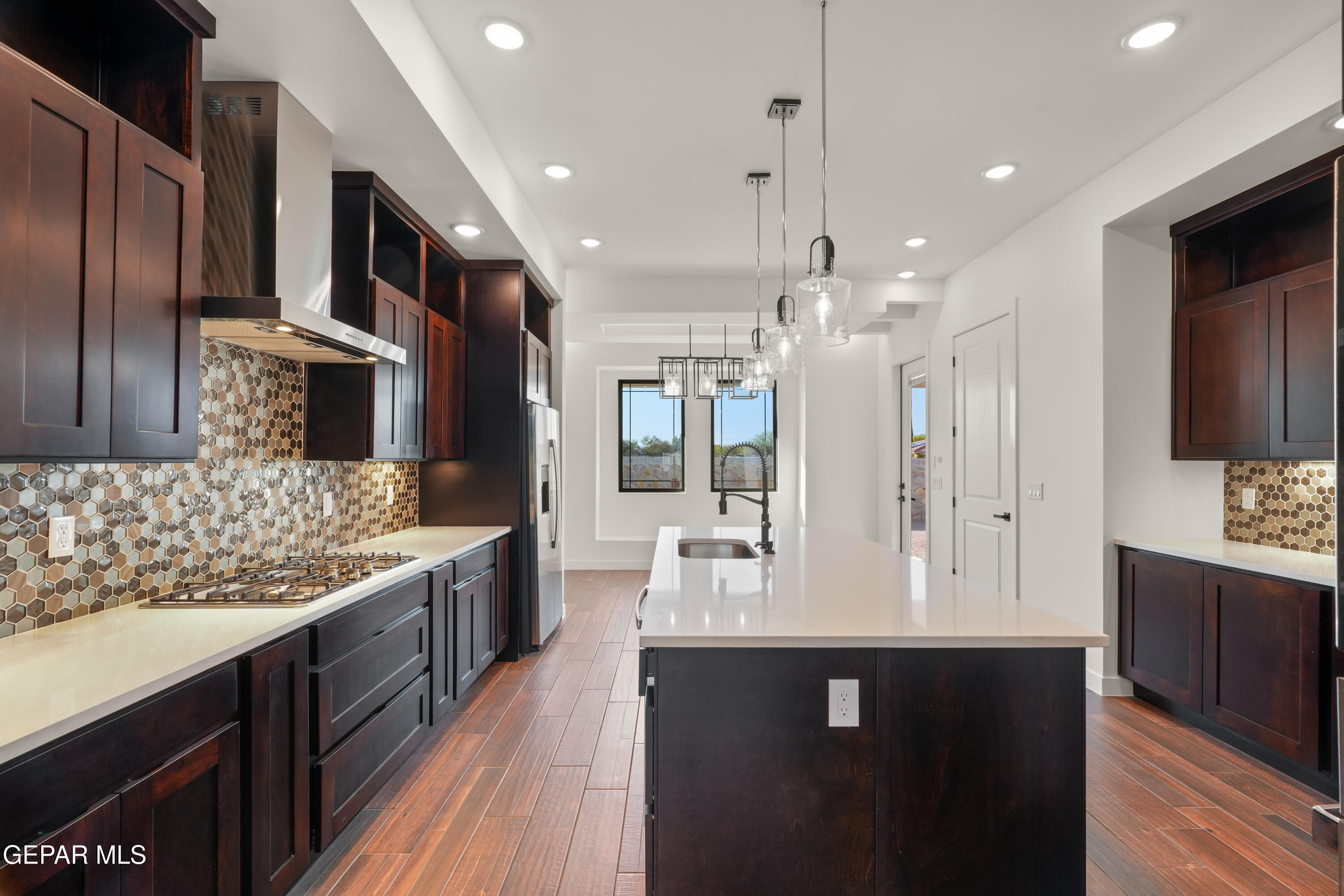 5953 Ruidoso Downs Street El Paso, TX 79932 - Photo 10 of 56 a large kitchen with stainless steel appliances kitchen island granite countertop a stove refrigerator and cabinets