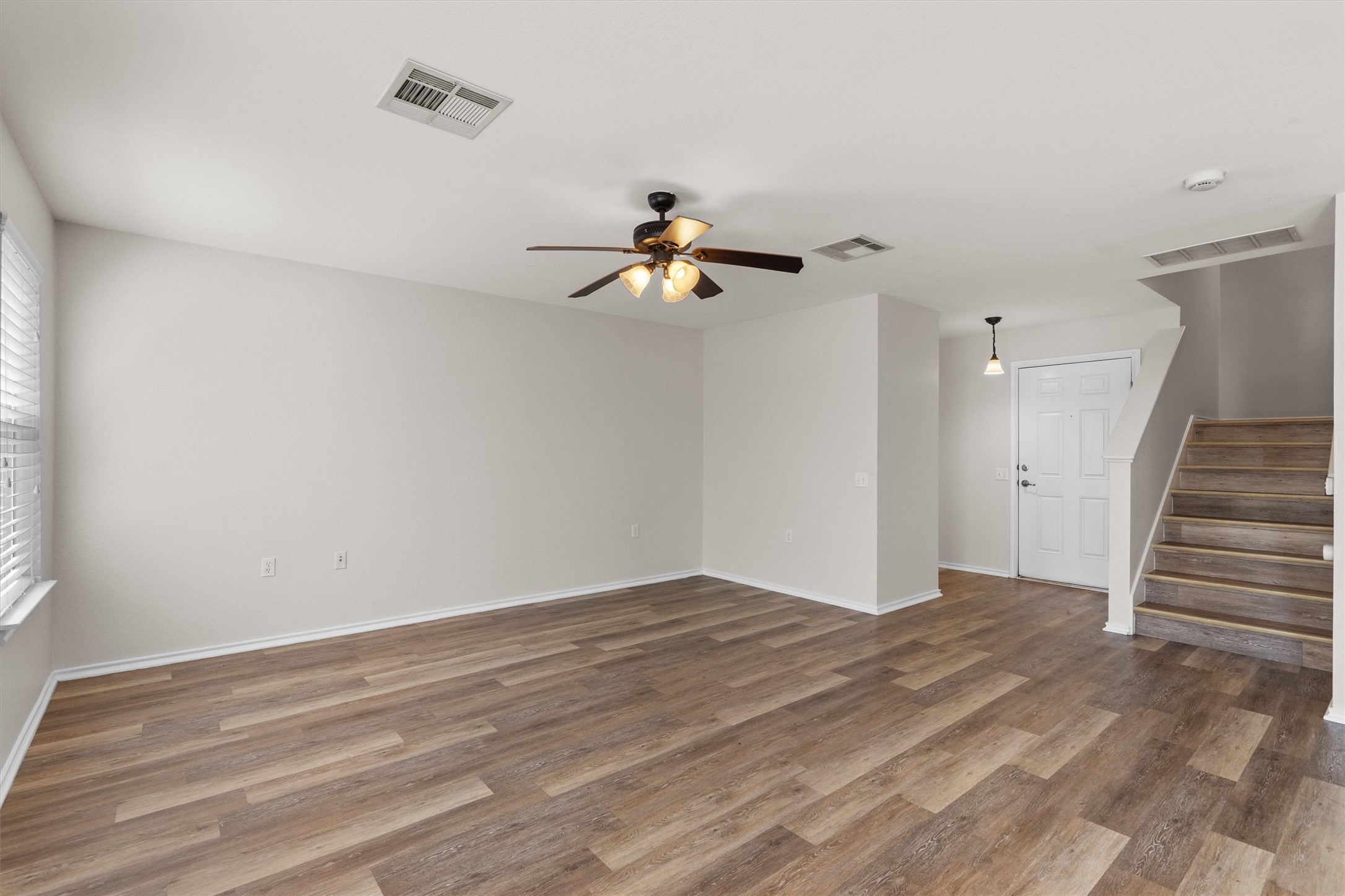5825 Silver Screen Drive Austin, TX 78747 - Photo 6 of 40 A versatile living area with warm wood-look flooring provides an inviting atmosphere.