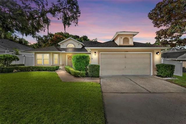 a front view of a house with a yard and garage