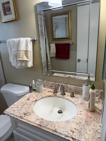 a bathroom with a granite countertop sink and a mirror