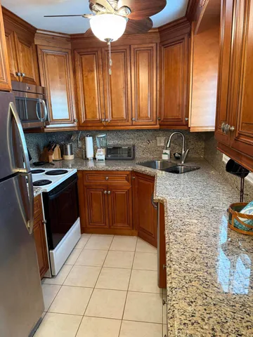 a kitchen with a sink a stove cabinets and wooden floor