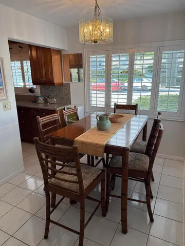 a view of a dining room with furniture a chandelier and wooden floor