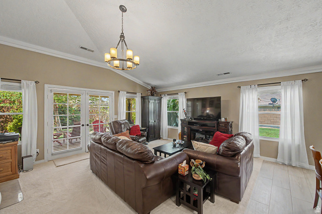 3034 Swiss Drive Santa Clara, UT 84765 - Photo 14 of 59 Living area featuring vaulted ceilings, a central chandelier, multiple windows, double glass doors, and a combination of carpet and wood-finish flooring