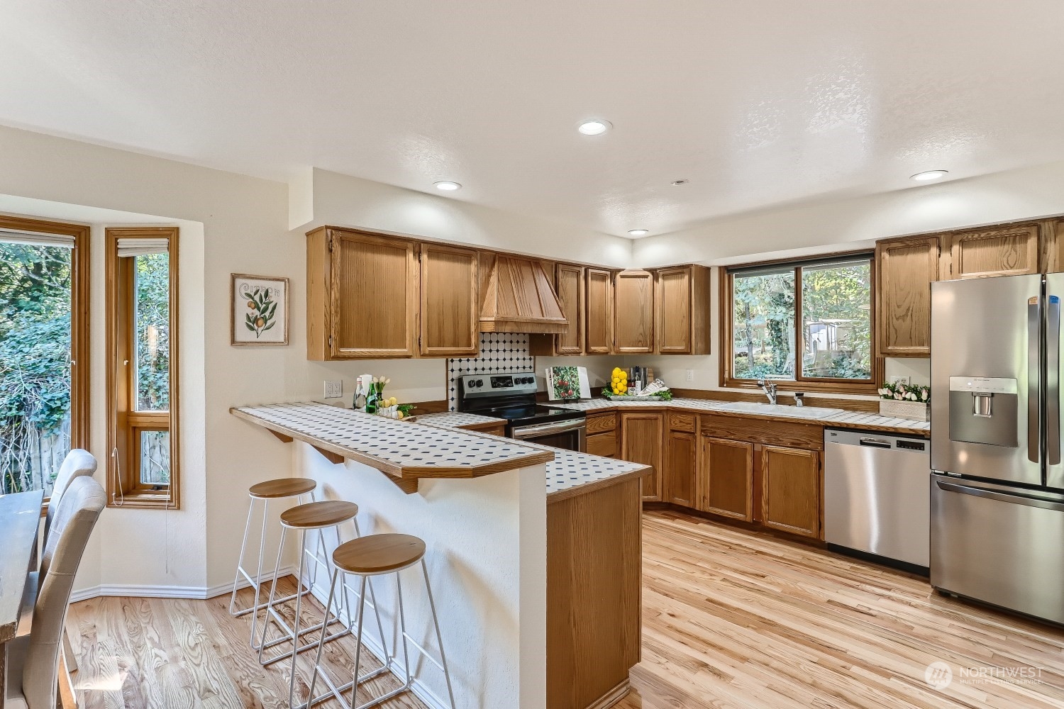 2626 242nd Place Southeast Bothell, WA 98021 - Photo 7 of 26 a kitchen with stainless steel appliances granite countertop a stove a refrigerator a sink and white cabinets with wooden floor