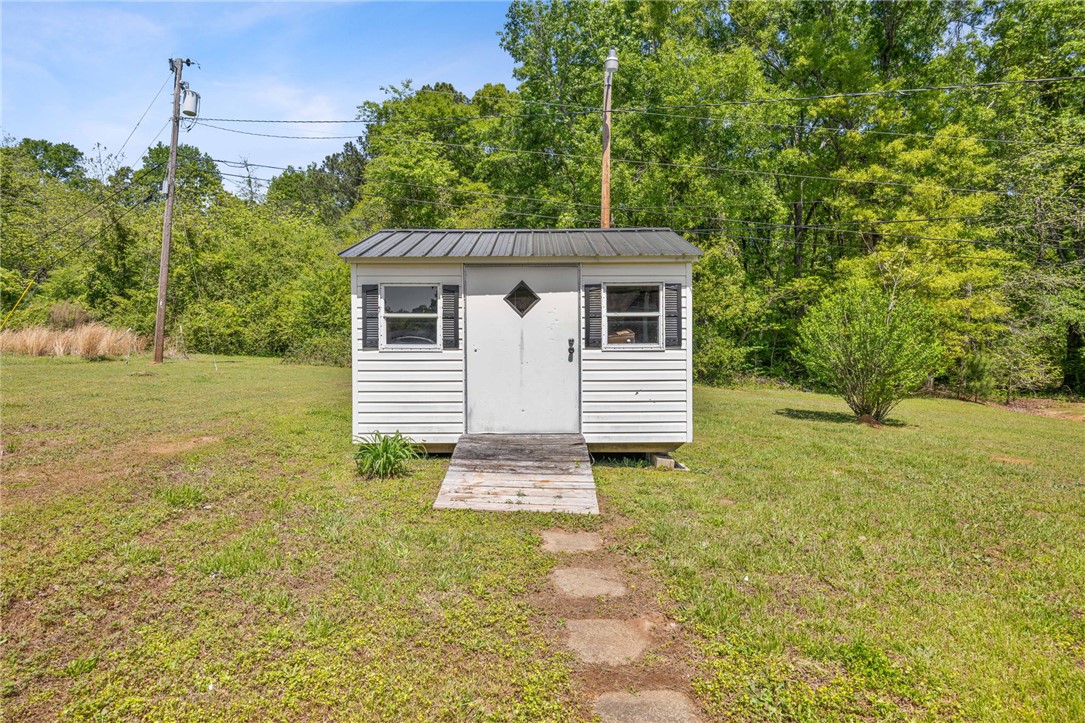 309 East Hampton Avenue Honea Path, SC 29654 - Photo 20 of 23 This charming utility structure offers practical outdoor storage in a serene, green setting.