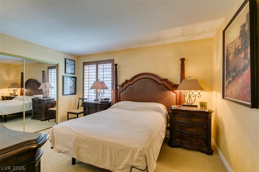 9325 West Desert Inn Road, Unit 244 Las Vegas, NV 89117 - Photo 30 of 55 A welcoming primary bedroom features comfortable carpeting and ample natural light from louvered windows.