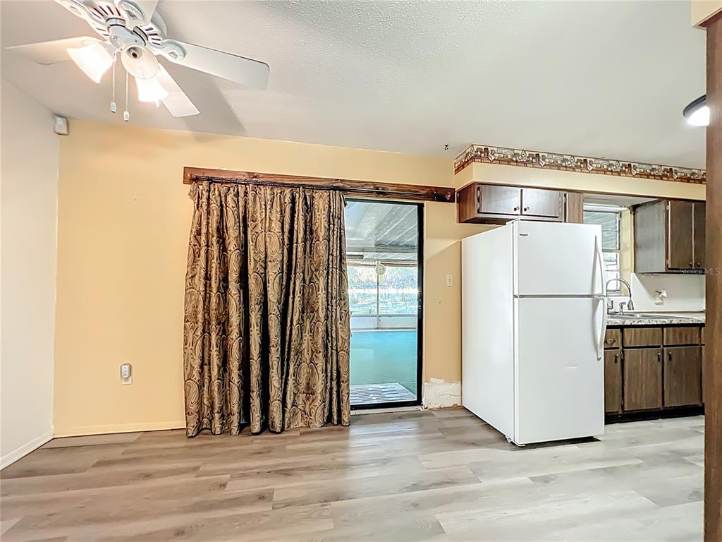 7802 Mizell Street Coleman, FL 34785 - Photo 12 of 44 wooden floor in an empty room and a kitchen