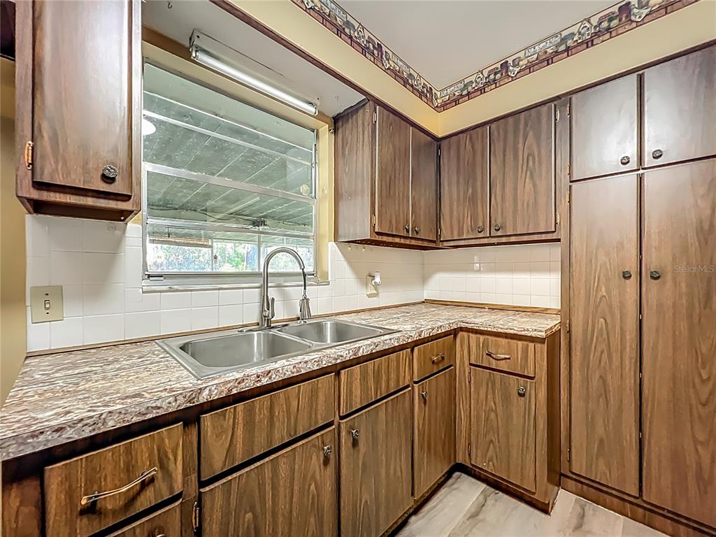 7802 Mizell Street Coleman, FL 34785 - Photo 13 of 44 a kitchen with granite countertop a sink stainless steel appliances and cabinets