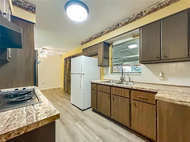 a kitchen with a sink stove and refrigerator