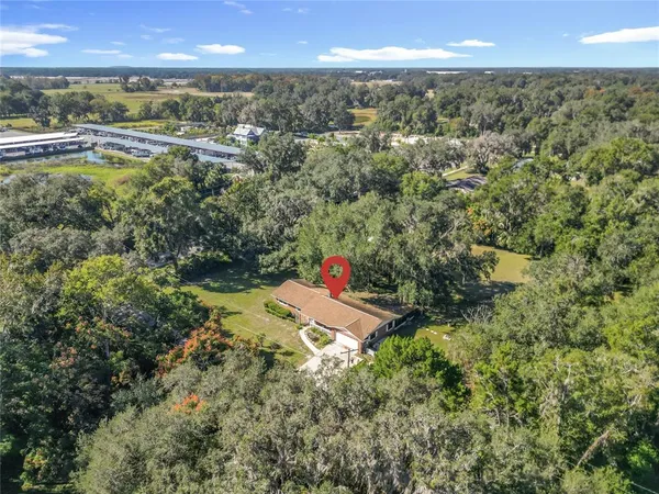 an aerial view of residential houses with outdoor space and trees