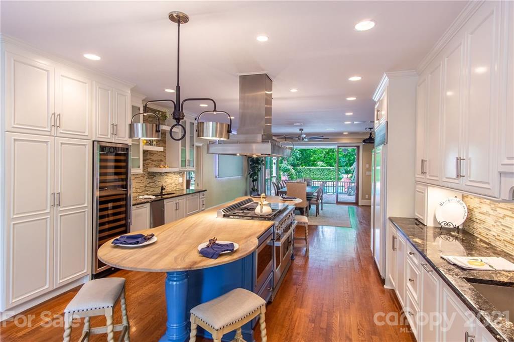 2132 Rolston Drive Charlotte, NC 28207 - Photo 12 of 48 a kitchen with stainless steel appliances kitchen island granite countertop a table chairs and a wooden floor