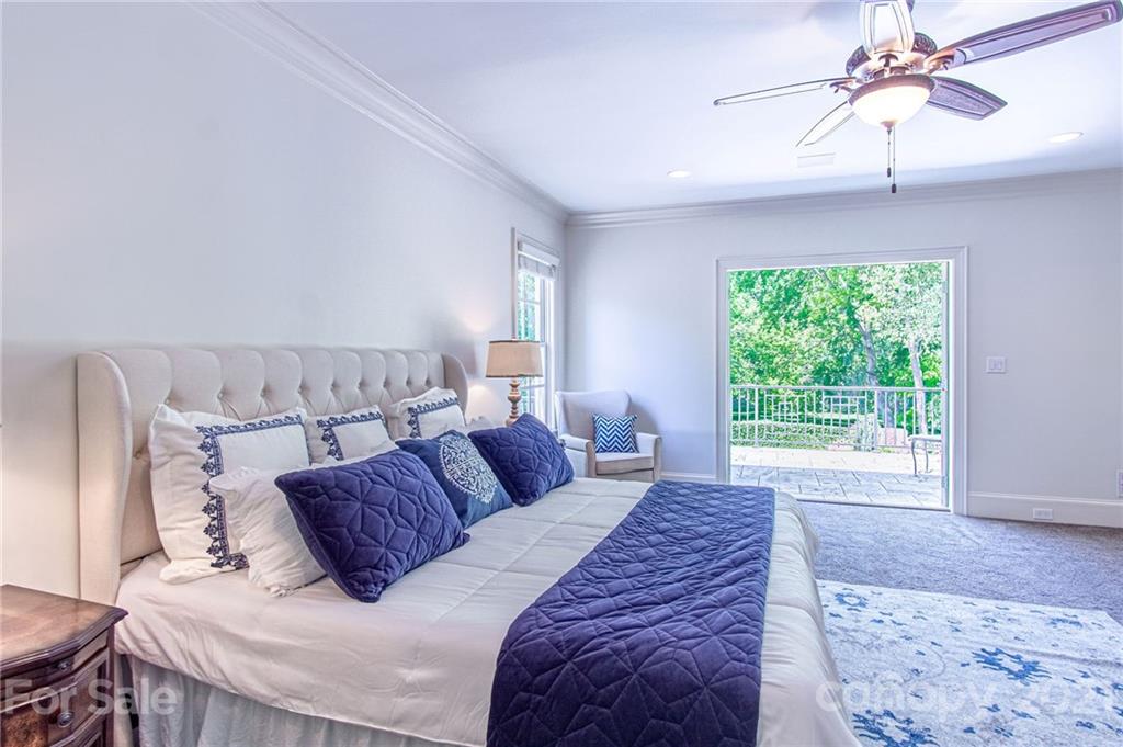2132 Rolston Drive Charlotte, NC 28207 - Photo 38 of 48 a bedroom with a large bed and a chandelier