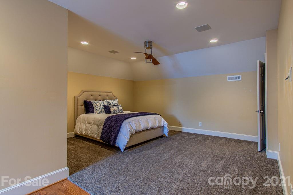 2132 Rolston Drive Charlotte, NC 28207 - Photo 41 of 48 a spacious bedroom with a bed and a chandelier