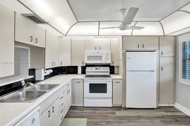 a view of a kitchen with a dishwasher cabinets and a window