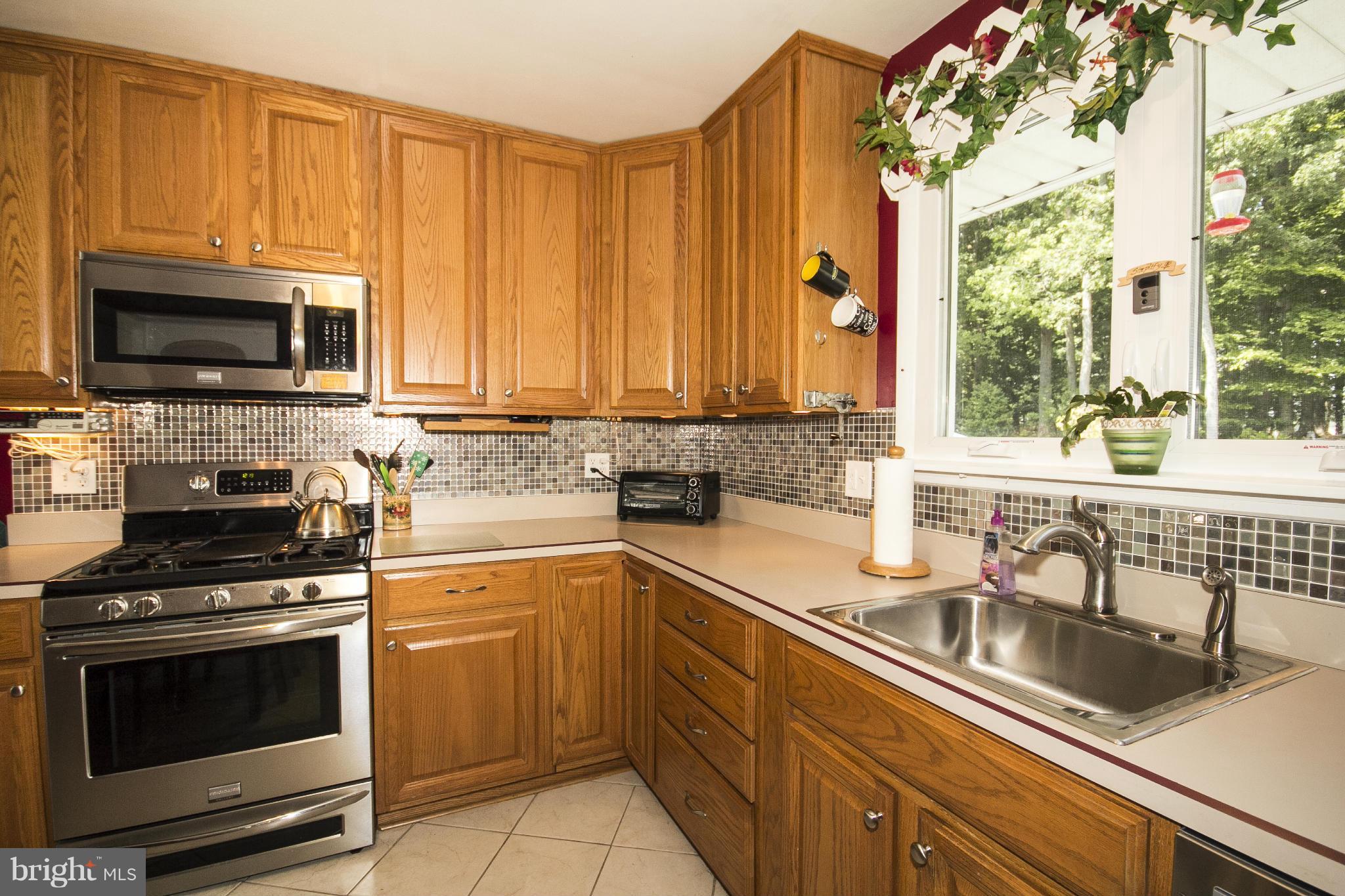 9810 Gunforge Road Perry Hall, MD 21128 - Photo 6 of 30 a kitchen with stainless steel appliances a stove a sink a microwave and cabinets