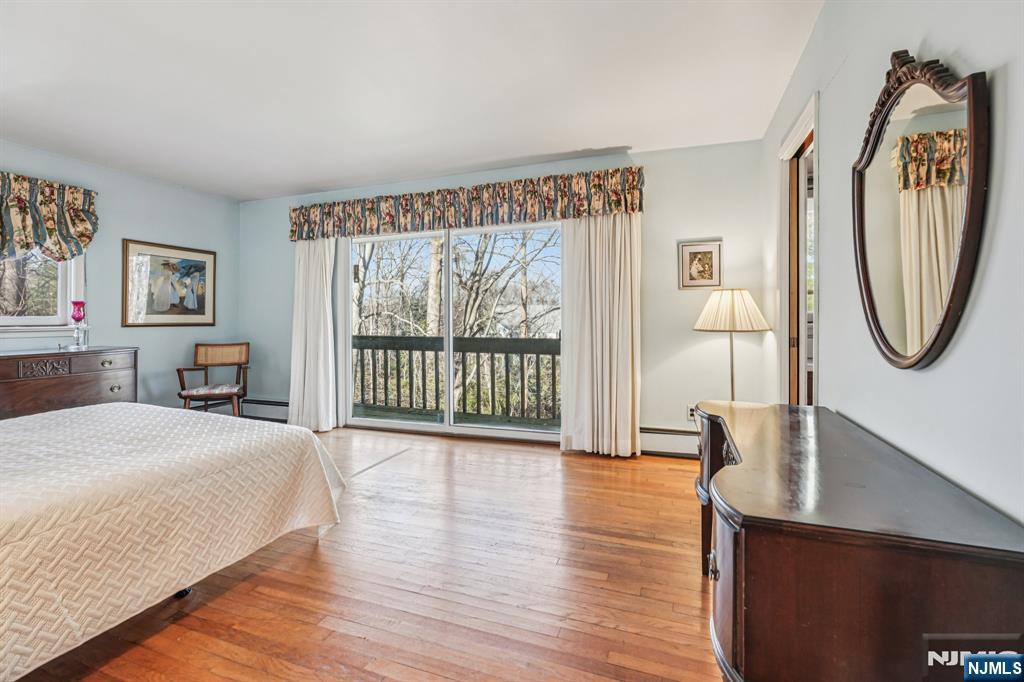 873 Olentangy Road Franklin Lakes, NJ 07417 - Photo 20 of 41 a spacious bedroom with a bed a mirror and a large window