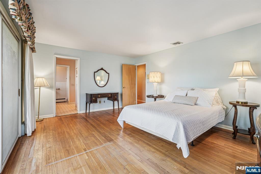 873 Olentangy Road Franklin Lakes, NJ 07417 - Photo 23 of 41 a spacious bedroom with a bed a table and painting on the wall
