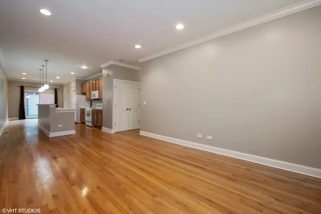 a view of a big room with wooden floor and a window