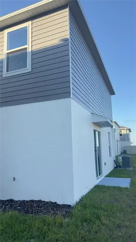 a view of backyard with plants and wooden fence