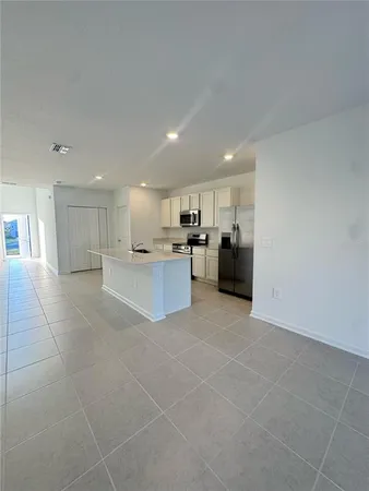 a large white kitchen with a stove a sink and a refrigerator