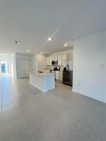 a large white kitchen with a stove a sink and a refrigerator